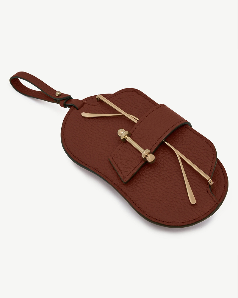 Walnut pebbled leather sunglasses case with gold-toned hardware and wrist strap.