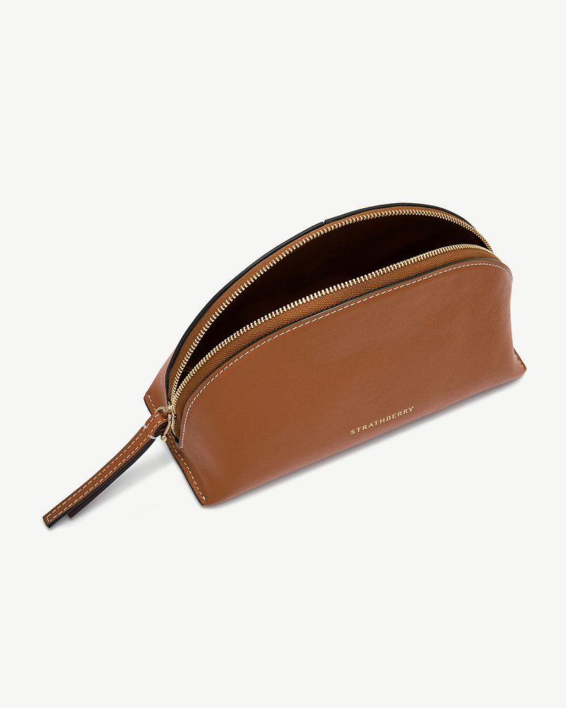 Tan Nest pouch with gold zip, wrist strap and Strathberry logo.