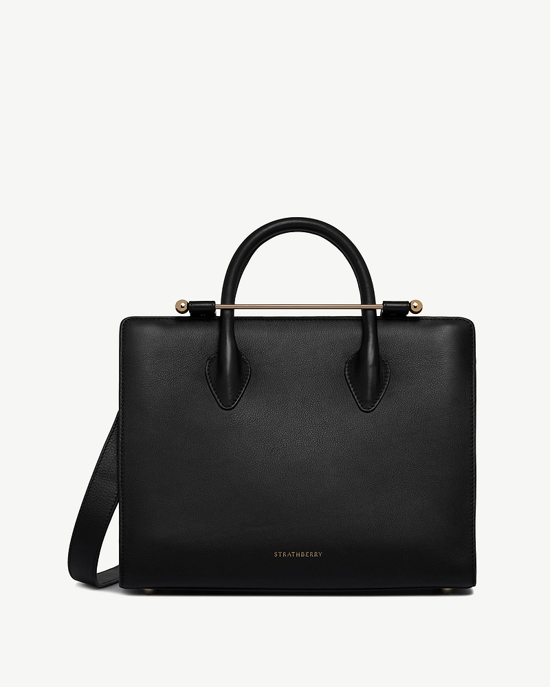 Black Strathberry midi tote with rounded top handles, gold bar and shoulder strap