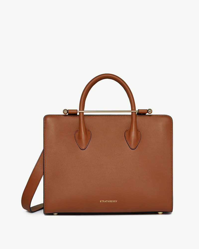 Chestnut leather midi tote with top handles, shoulder strap, gold bar detail and Strathberry logo.
