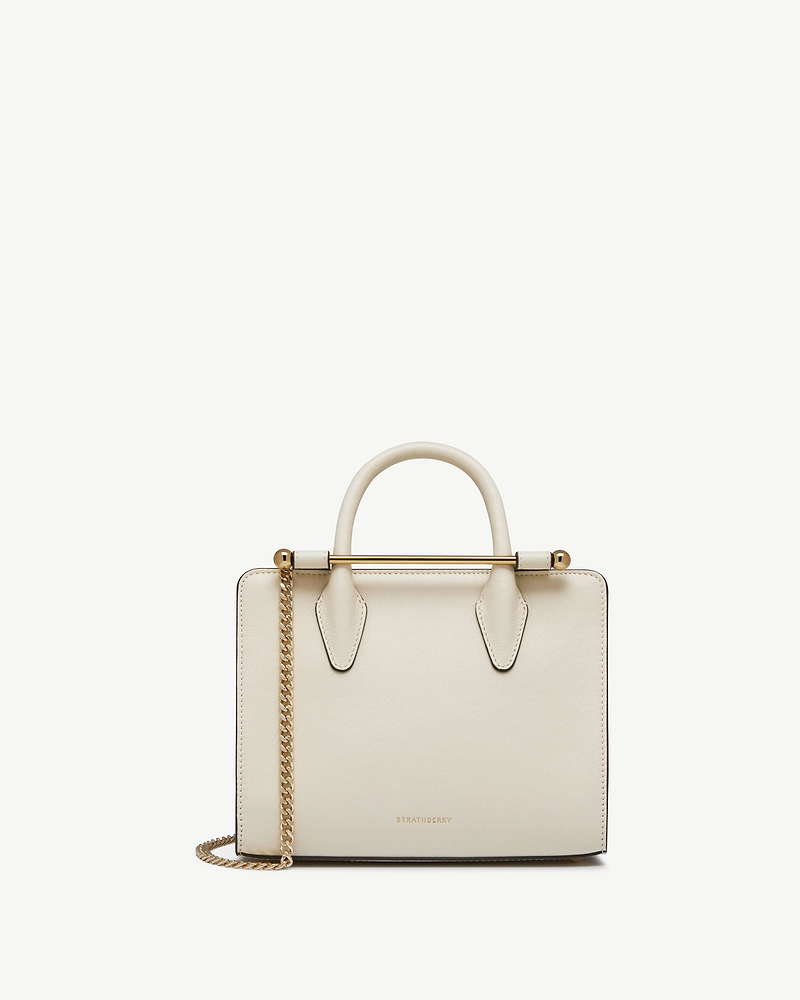 Vanilla mini tote with top handles, gold bar and chain strap, Strathberry logo.