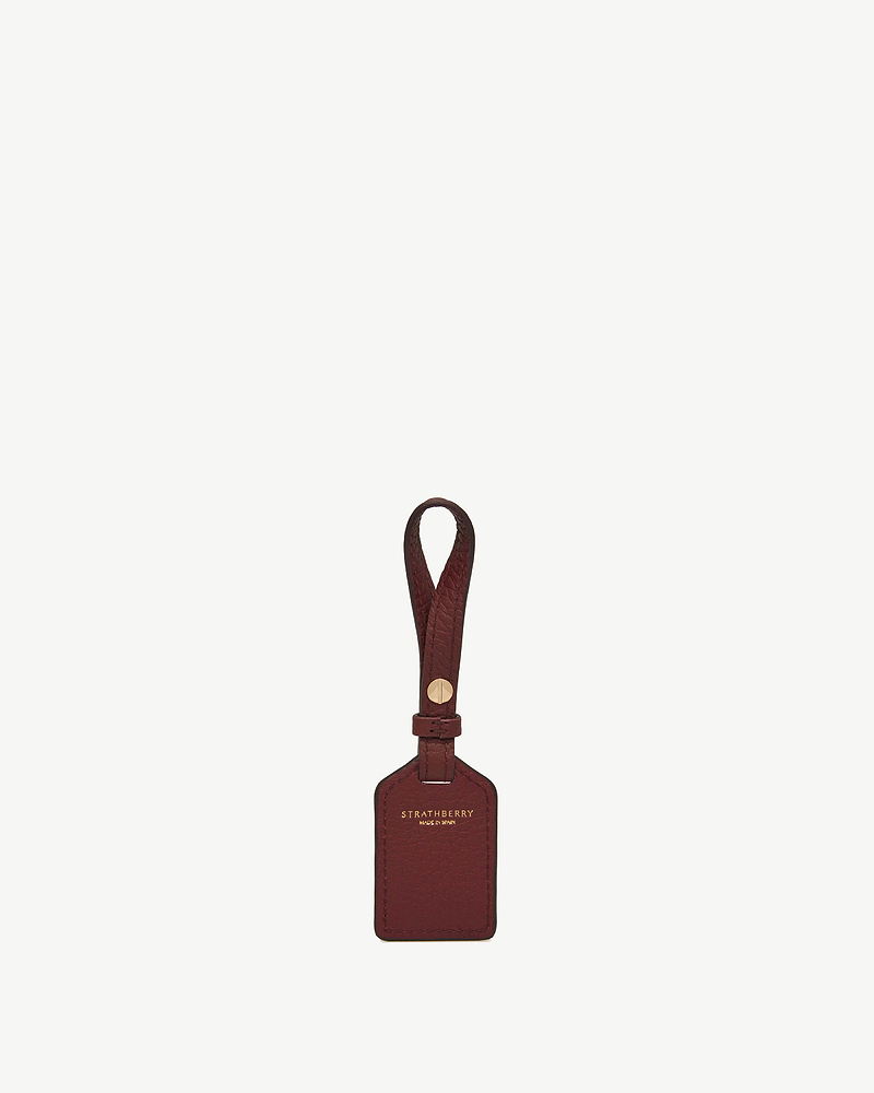 Oxblood leather luggage tag with loop strap and gold-tone screw, Strathberry logo