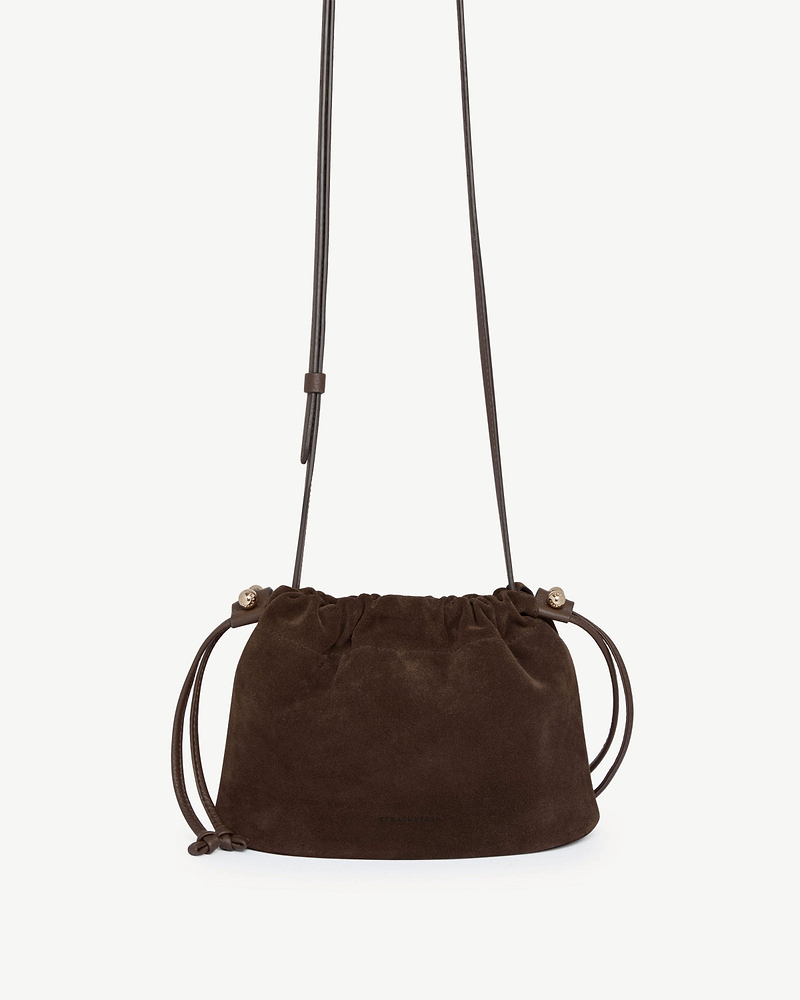 Chocolate suede Strathberry Charlotte drawstring bag with long strap and knotted ties.