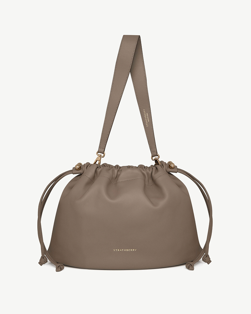 Taupe Charlotte Midi drawstring bag with shoulder strap and gold Strathberry logo