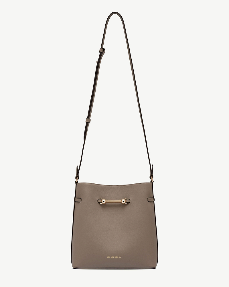 Taupe Corda bucket bag with adjustable shoulder strap and gold Strathberry logo