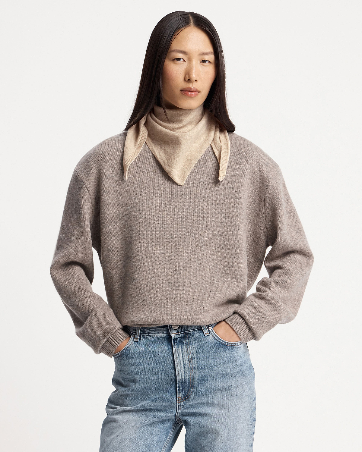 Model wearing an oat-coloured cashmere bandana tied around her neck.