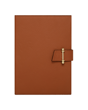 Tan textured leather notebook with strap and gold bar clasp.