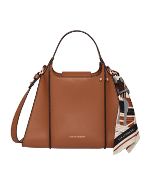 Strathberry tan Arkshell leather top-handle bag with patterned scarf tied to strap