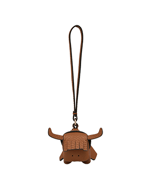Tan highland cow leather bag charm with long loop strap and stitched fringe.