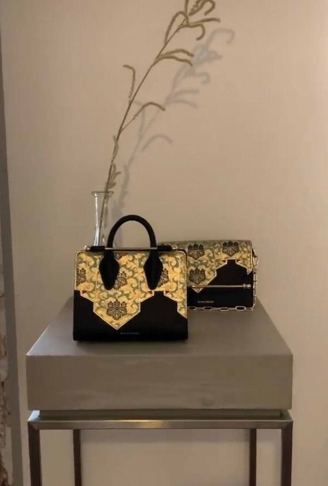 A black and gold purse sitting on top of a table