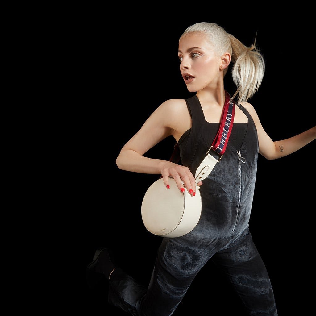 A woman in black jumpsuit holding a white frisbee