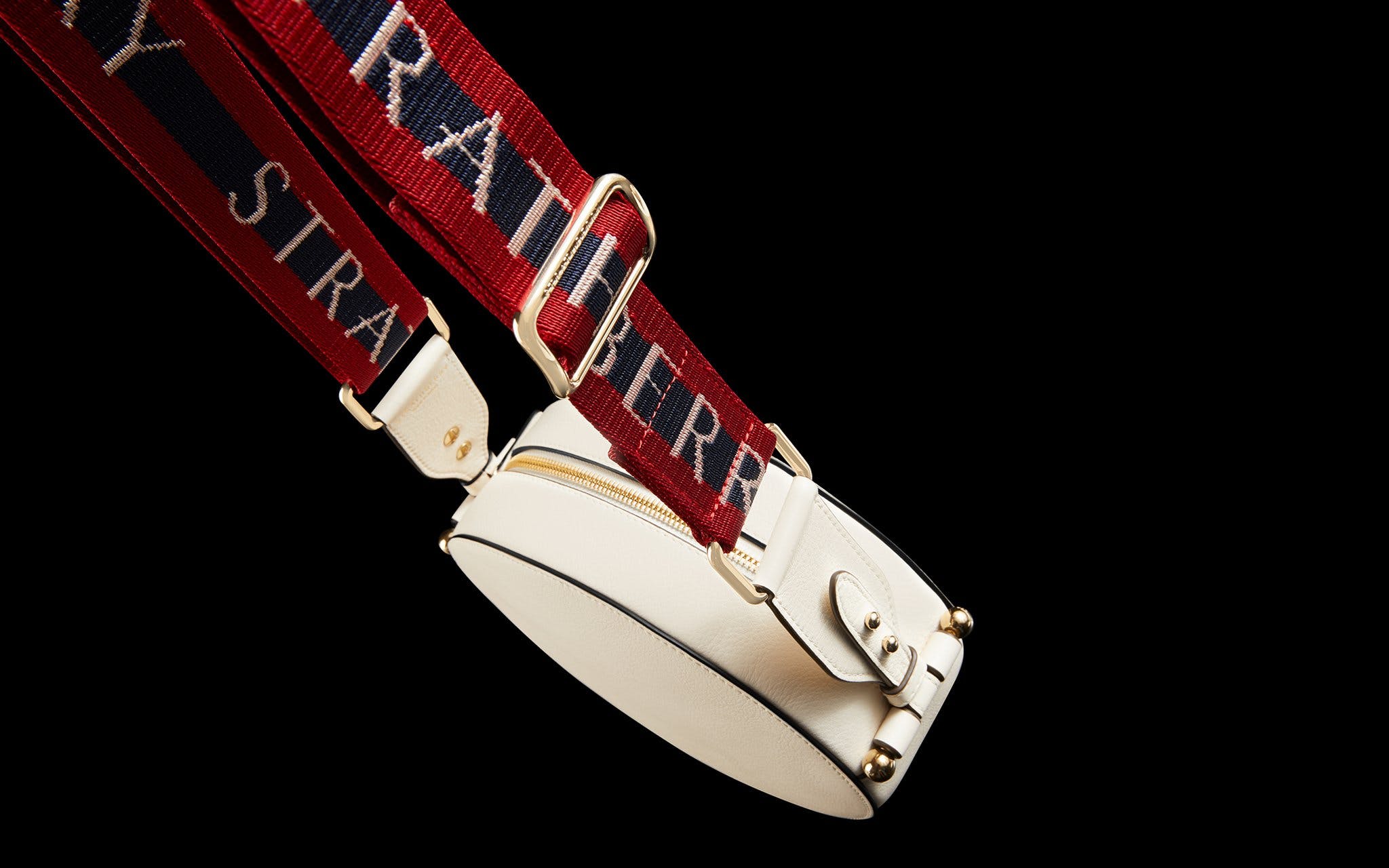 A white purse with a red and blue strap