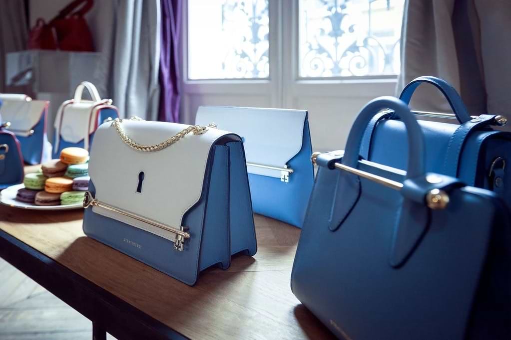 A row of blue and white purses sitting on top of a table
