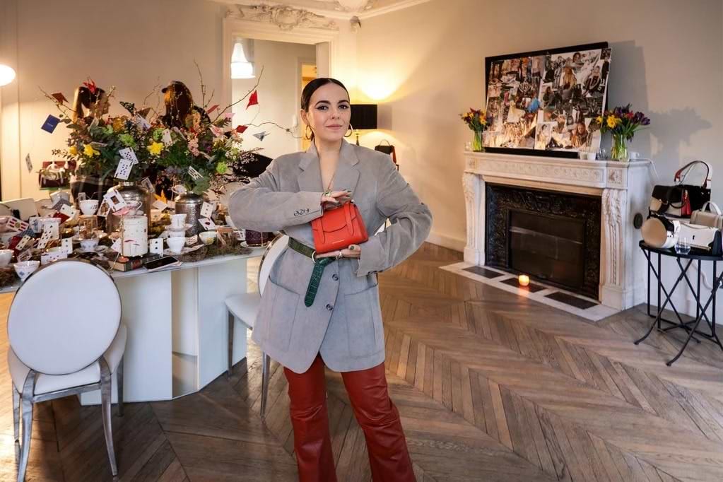 A woman standing in a room holding a purse