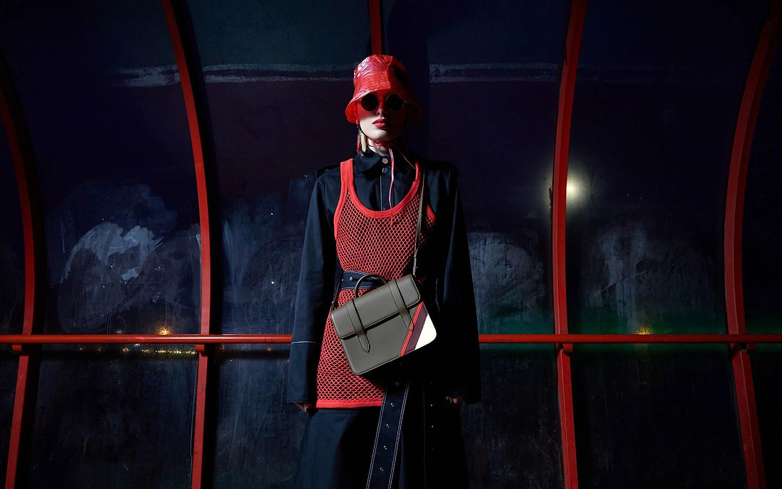 A woman in a red and black outfit and sunglasses