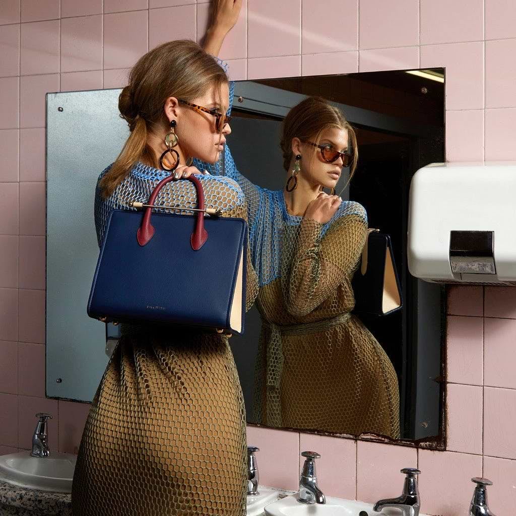 Two women standing in front of a bathroom mirror