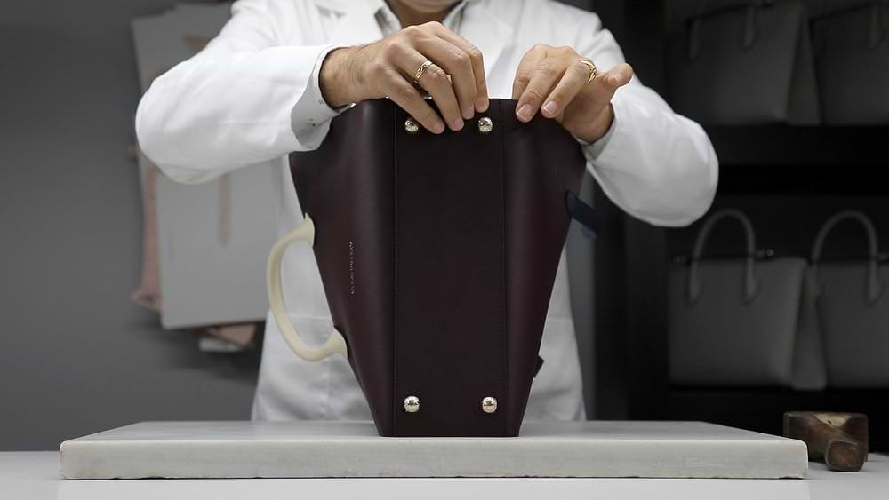 A woman holding a purse in her hands