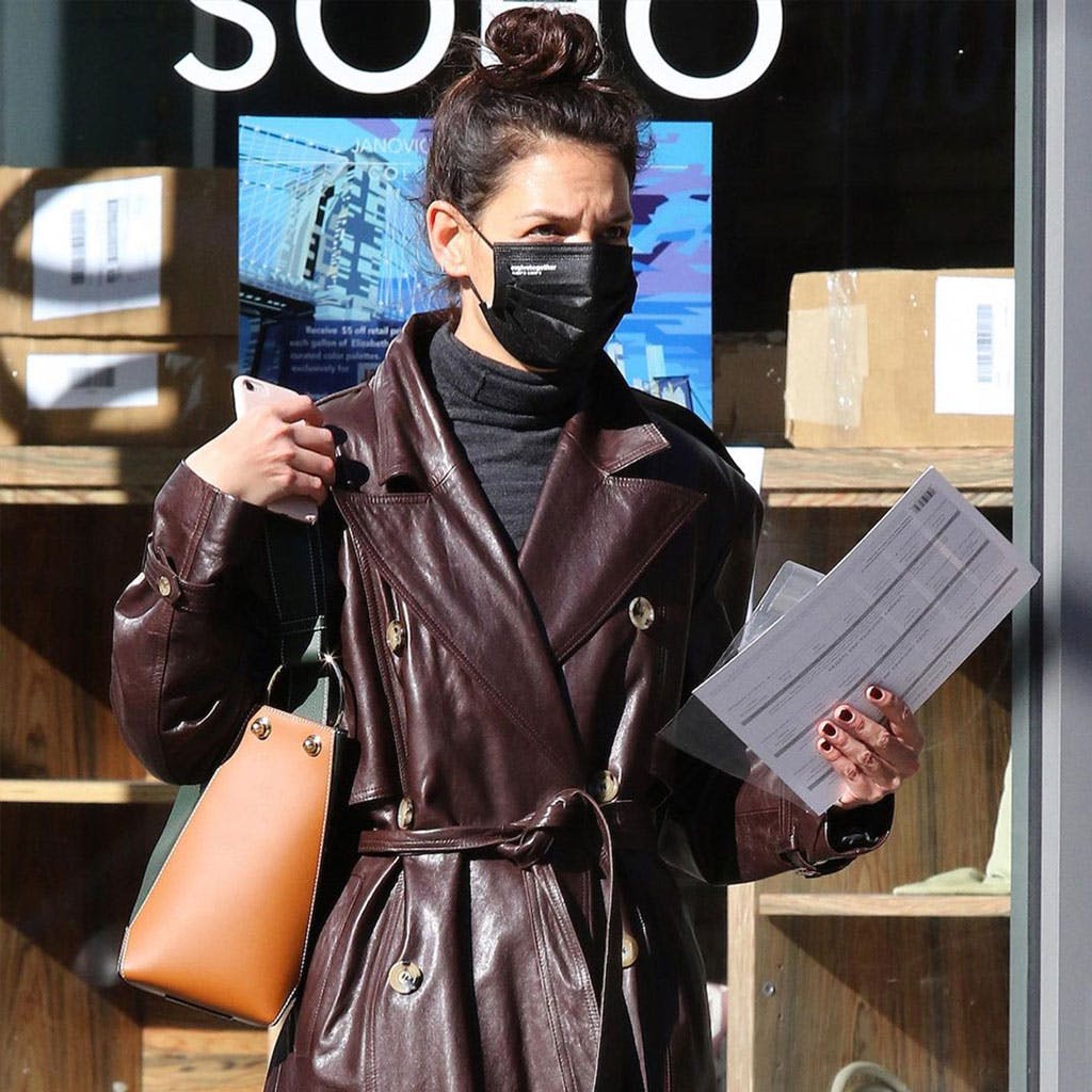 A woman wearing a face mask while walking down the street