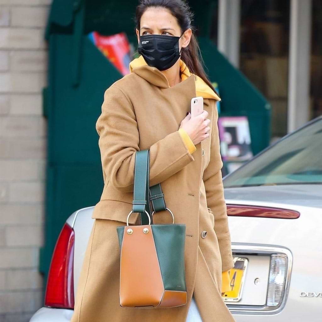 A woman wearing a face mask while walking down the street