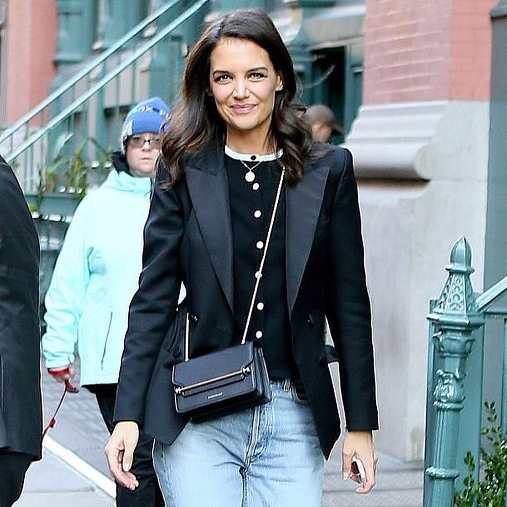 A woman walking down the street with a purse