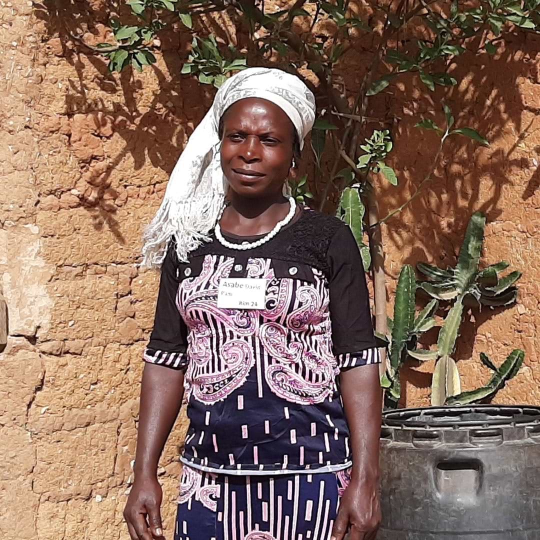 A woman standing next to a potted plant