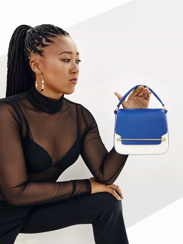A woman holding a blue and white purse