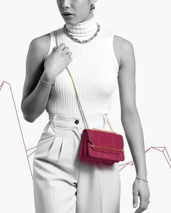 A woman in a white top holding a red purse