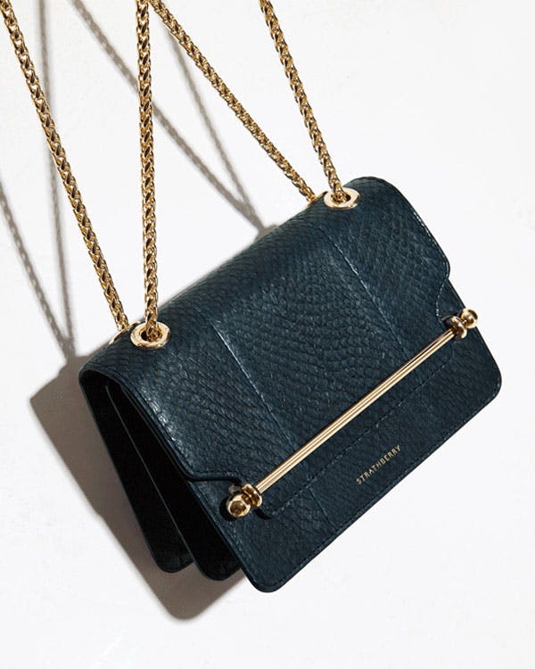 A black purse sitting on top of a white table