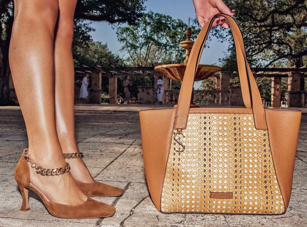 A woman's legs and a handbag on the ground