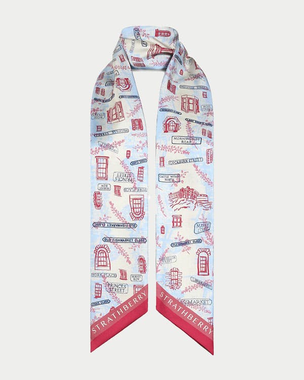A white scarf with red and blue designs on it