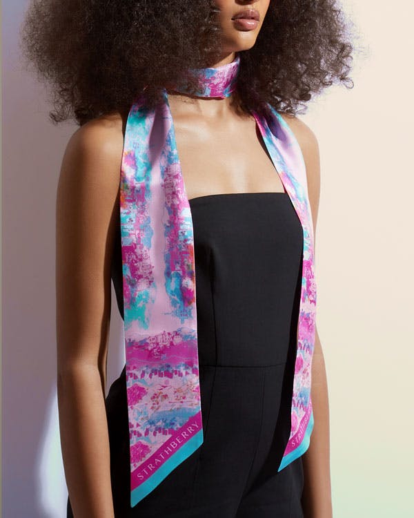 A woman with an afro wearing a pink and blue scarf