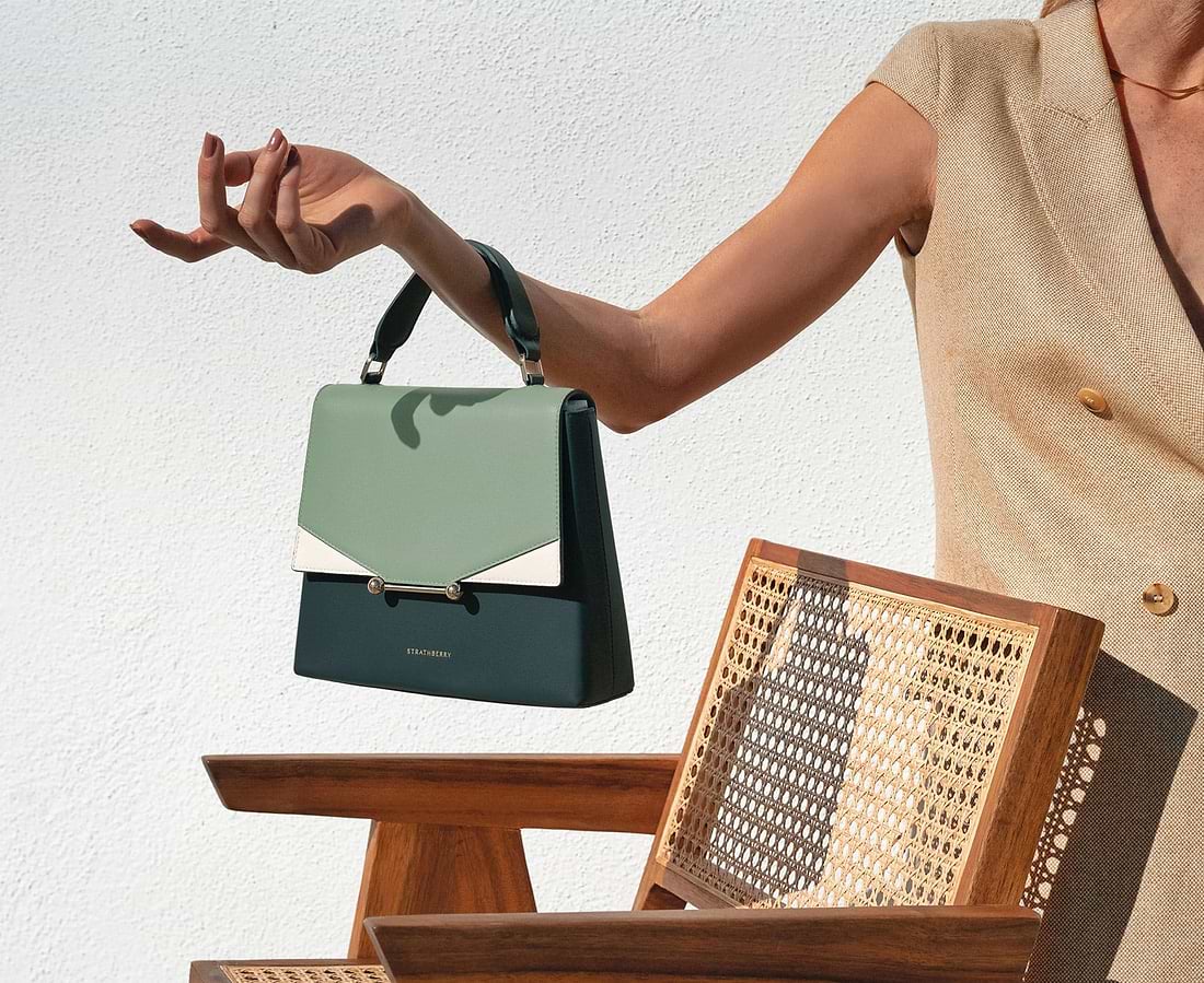 A woman holding a green and white purse