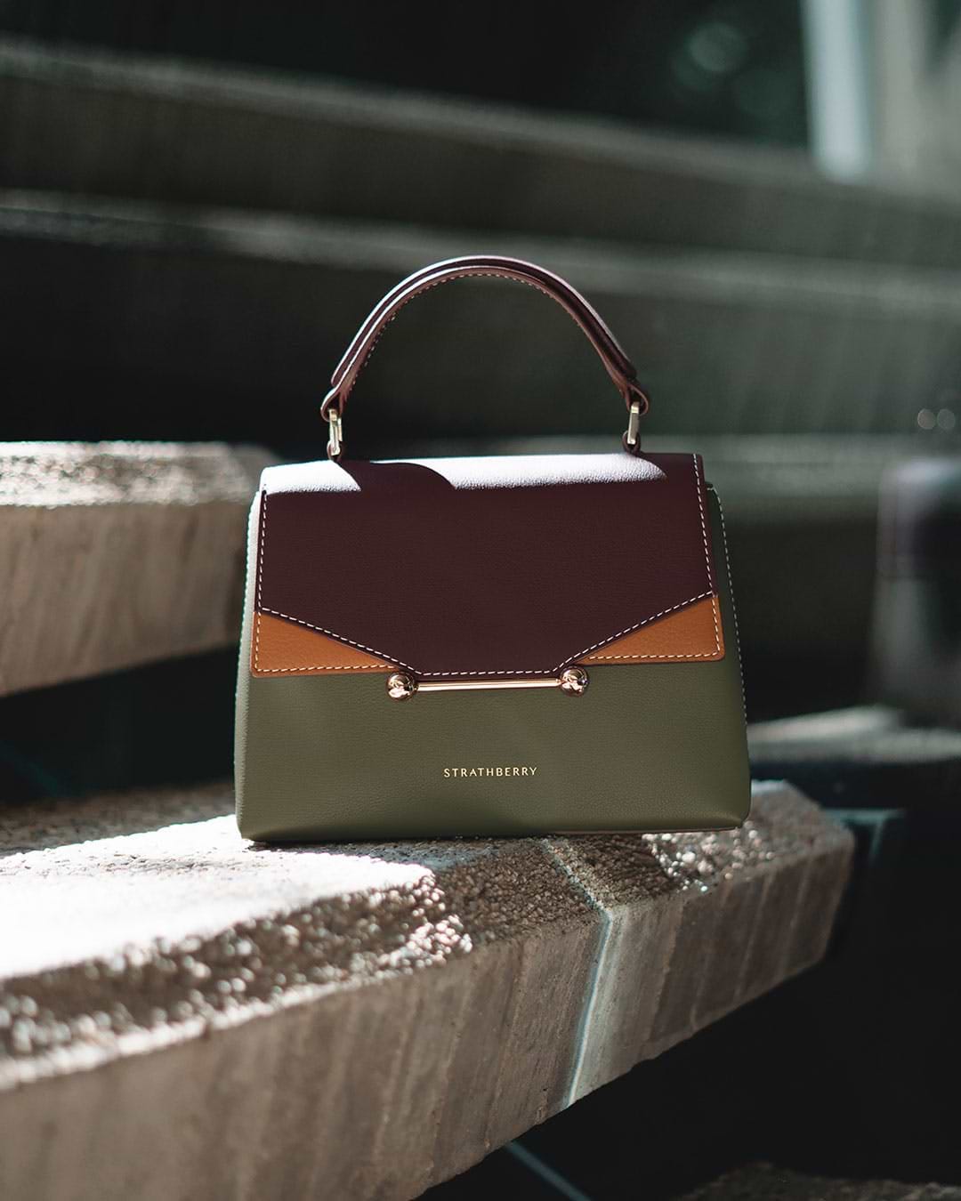 A purse sitting on top of a wooden bench