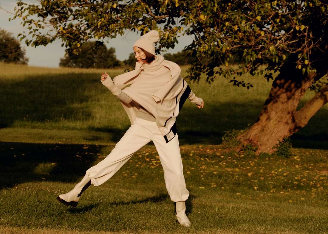 A man in a white outfit is throwing a frisbee