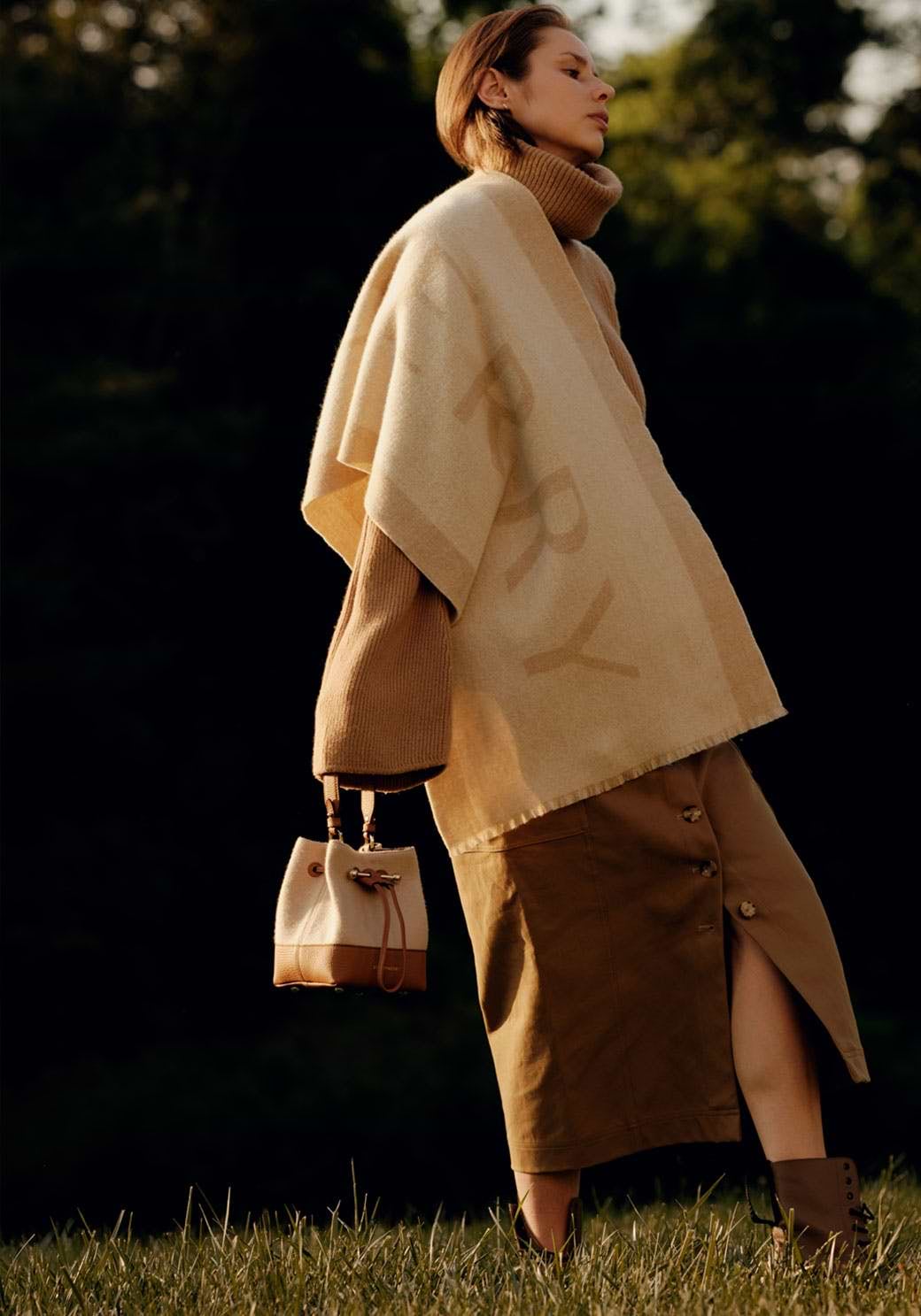 A woman in a beige coat and brown skirt