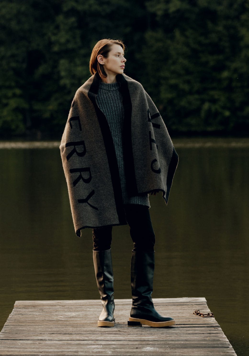 A woman standing on a dock with a blanket over her