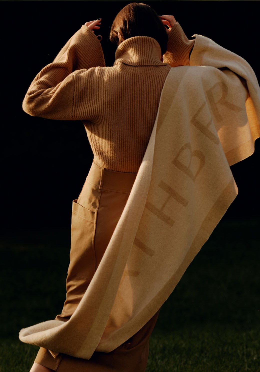 A woman wrapped in a blanket in the dark