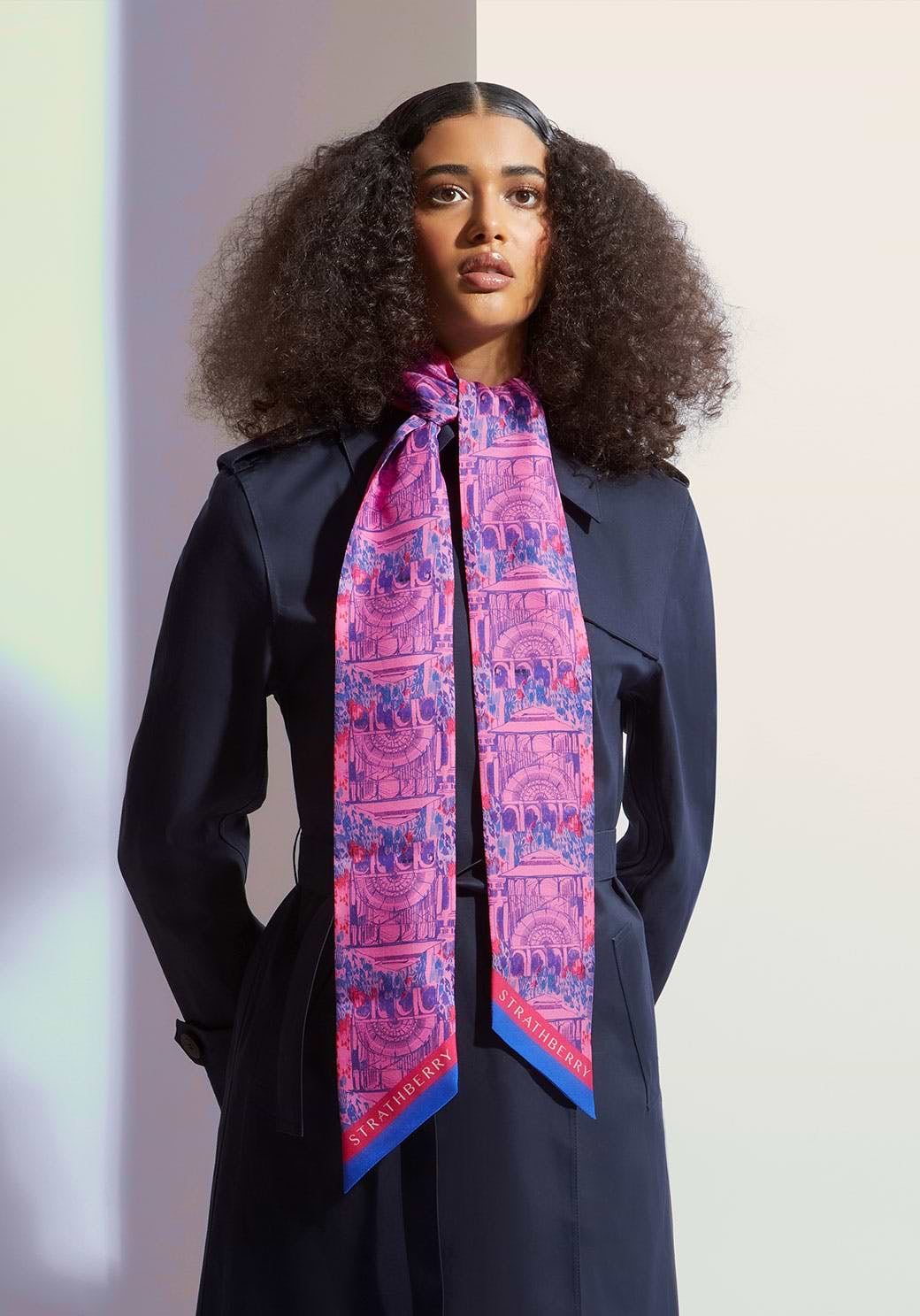 A woman in a black dress and a pink and blue scarf