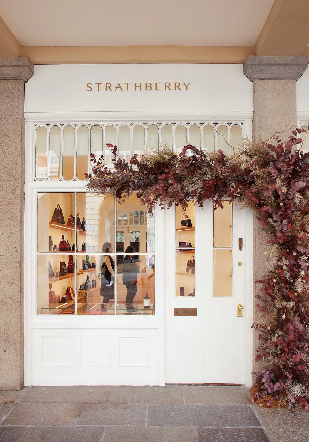 A store front with a vine hanging over the door