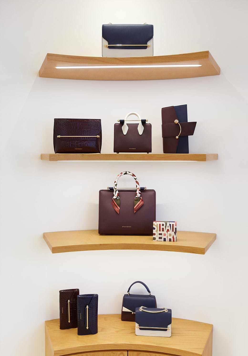 A couple of shelves with purses on top of them