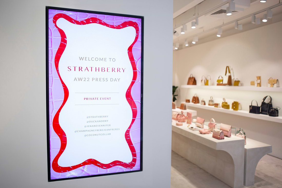A welcome sign hangs on the wall of a store