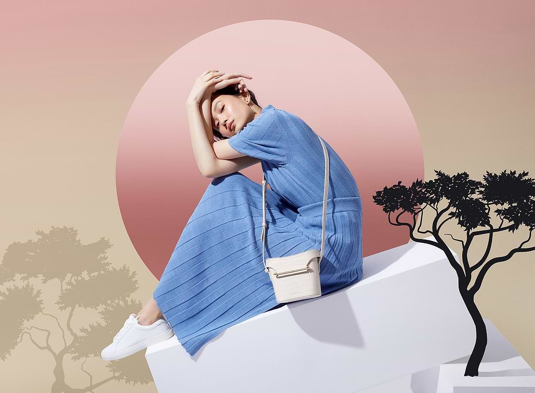 A woman in a blue dress is sitting on a ledge