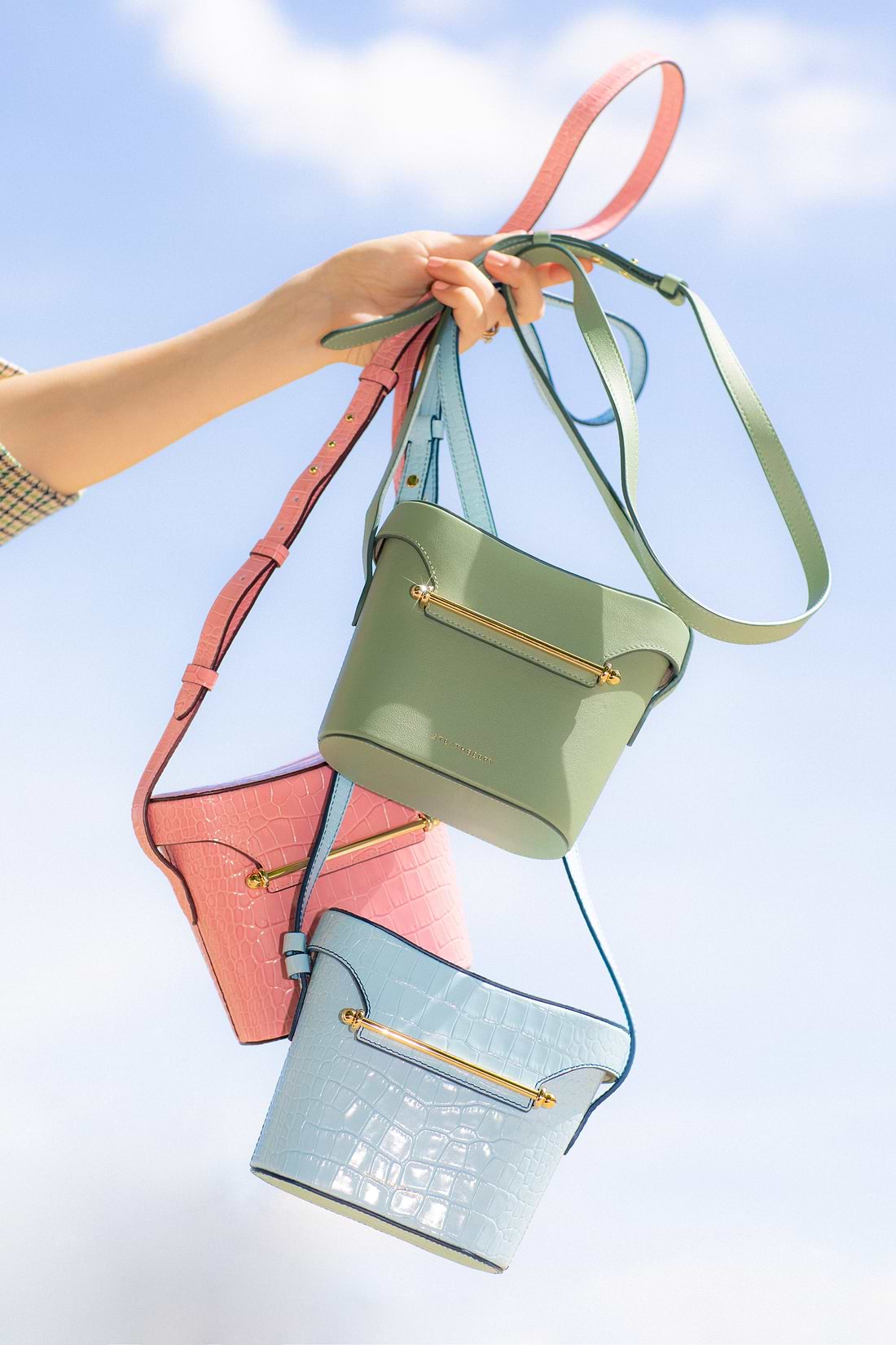 A person holding a bunch of purses in the air