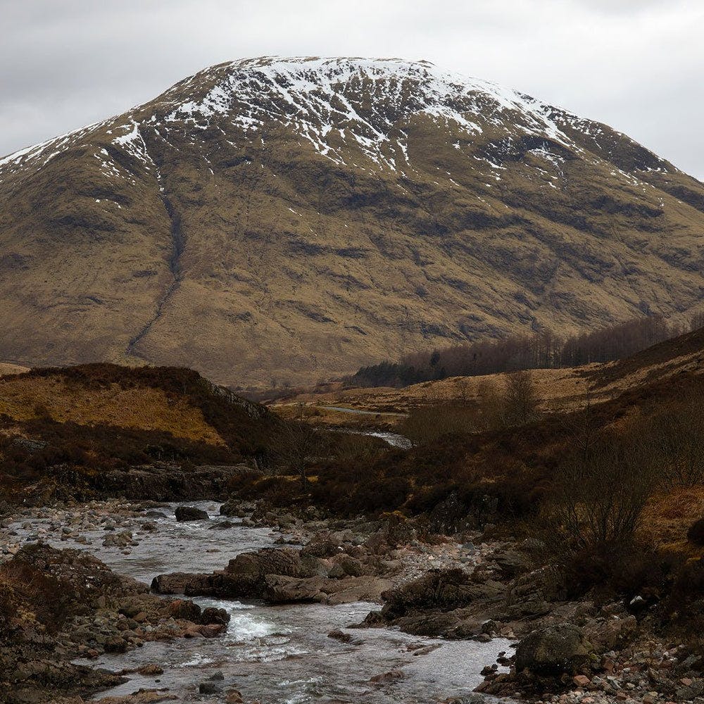 A mountain with a stream running through it