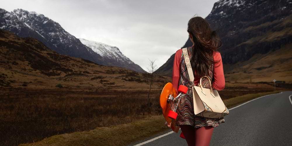 A woman is walking down the road with a bag