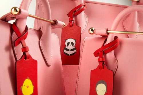 A group of pink purses with tags on them
