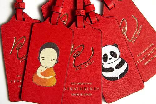 A group of red luggage tags with panda and panda on them