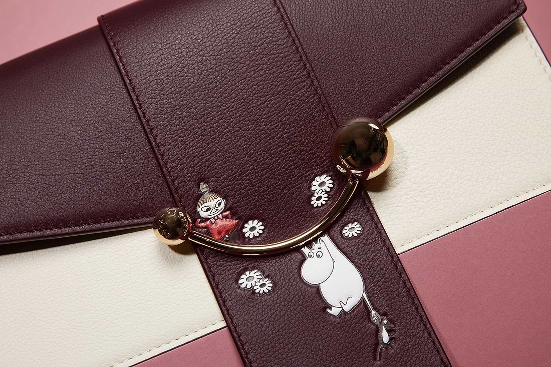 A close up of a purse on a pink and white striped surface