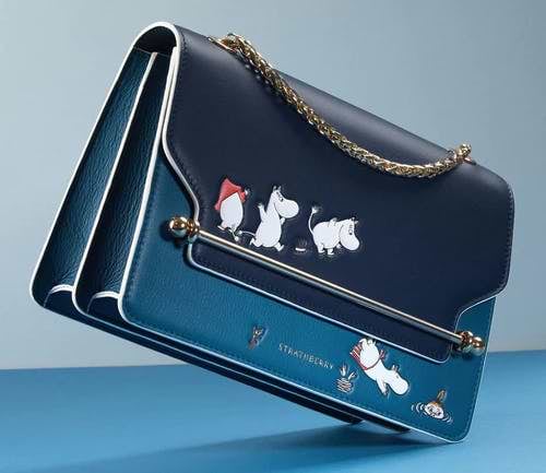 A blue purse with cats and dogs on it