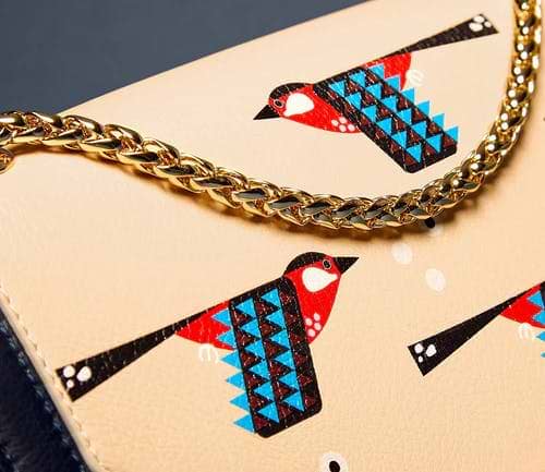 A white purse with a bird design on it